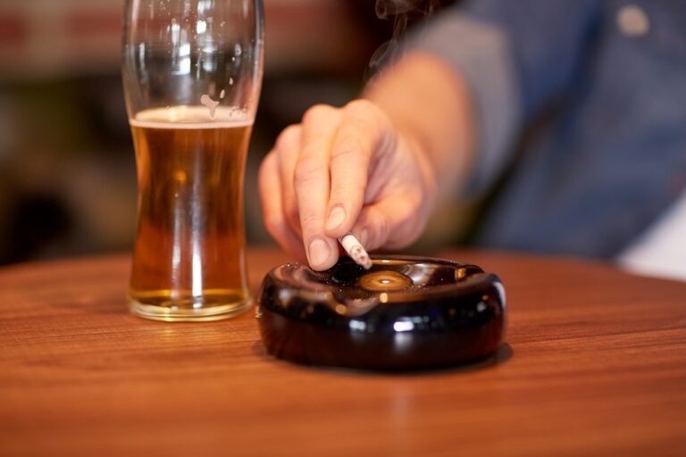 close up of man smoking cigarette at bar