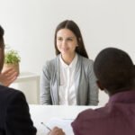 Confident applicant smiling at job interview with diverse hr man