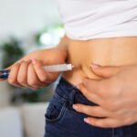 A diabetic patient using insulin pen for making an insulin injection at home. Young woman control diabetes. Diabetic lifestyle