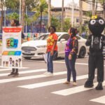 Equipe técnica NEACA e bonecos da Arana no semáforo em Caxias
