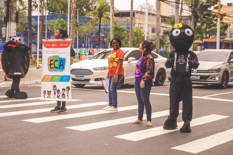 Equipe técnica NEACA e bonecos da Arana no semáforo em Caxias